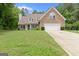 Charming two-story home with brick facade, manicured lawn, and an attached two-car garage at 320 Cobb Ct, Hampton, GA 30228