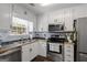 Bright kitchen with stainless steel appliances, white cabinets, and a window overlooking the yard at 320 Cobb Ct, Hampton, GA 30228