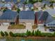 An aerial view displays a home with backyard tennis courts, surrounded by lush landscaping at 2047 Gazebo Ln, Snellville, GA 30078