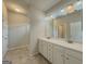 Well-lit bathroom with double vanity, marble countertop, and walk-in glass shower at 2047 Gazebo Ln, Snellville, GA 30078