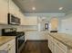 Well-lit kitchen boasts granite countertops, white cabinetry, stainless steel appliances, and dark hardwood flooring at 2047 Gazebo Ln, Snellville, GA 30078