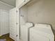 Bright laundry room featuring a washer, dryer, and shelving at 2047 Gazebo Ln, Snellville, GA 30078