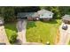 Aerial view of a home with a large, green lawn, covered parking, and mature trees at 1486 Harbour Oaks Rd, Tucker, GA 30084