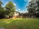 The backyard includes a grass lawn, trees, a house with brick and siding, and a partially covered area at 1486 Harbour Oaks Rd, Tucker, GA 30084