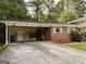 Close-up of brick home featuring covered parking and well maintained yard at 1486 Harbour Oaks Rd, Tucker, GA 30084