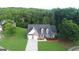 Aerial view of a beautiful home with a large front lawn in a lush, wooded neighborhood at 185 Stewart Glen Dr, Covington, GA 30014