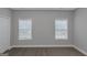 Bright bedroom features neutral walls, carpet, two windows, and a closet at 185 Stewart Glen Dr, Covington, GA 30014