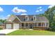 Charming brick home with a two-car garage, inviting front porch and lush landscaping at 185 Stewart Glen Dr, Covington, GA 30014
