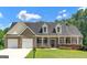 Charming brick home with a two-car garage, inviting front porch and lush landscaping at 185 Stewart Glen Dr, Covington, GA 30014