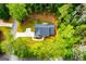 Aerial view of a newly constructed home surrounded by lush green trees showing the driveway and lawn at 5525 Belle Meade Dr, Villa Rica, GA 30180
