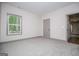 Bright, carpeted bedroom with natural light from large window; neutral gray trim at 5525 Belle Meade Dr, Villa Rica, GA 30180