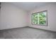 Bright, carpeted bedroom with natural light from large window; neutral gray trim at 5525 Belle Meade Dr, Villa Rica, GA 30180