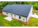 Back exterior of home with a gray roof, white siding, a small patio and a well maintained lawn at 5525 Belle Meade Dr, Villa Rica, GA 30180