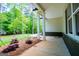 Covered front porch featuring stately columns, views of the lush greenery and the manicured landscaping of the front yard at 5525 Belle Meade Dr, Villa Rica, GA 30180