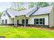 Charming single-story house featuring black shutters, a lush green lawn, and manicured landscaping in a tranquil setting at 5525 Belle Meade Dr, Villa Rica, GA 30180