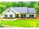 Inviting single-story home with a well-manicured lawn and charming curb appeal surrounded by a lush green forest at 5525 Belle Meade Dr, Villa Rica, GA 30180