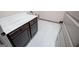 A laundry room with a dark cabinet and marble countertop, featuring white tile floors and modern fixtures at 5525 Belle Meade Dr, Villa Rica, GA 30180