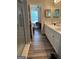 Bathroom view with double vanity, wood look floors, shower with grab bar, and view into the bedroom at 740 Pebble Blvd, Covington, GA 30016