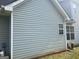 The exterior side of the home with light siding and windows, with greenery visible at 740 Pebble Blvd, Covington, GA 30016