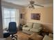 Cozy living room featuring a comfortable sofa, natural light from a window, and a ceiling fan at 740 Pebble Blvd, Covington, GA 30016