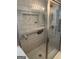 Bathroom shower featuring white tile walls with a built in shower caddy and grab bar at 740 Pebble Blvd, Covington, GA 30016