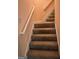 Carpeted stairway featuring a white handrail against peach colored walls at 740 Pebble Blvd, Covington, GA 30016
