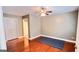 Spacious bedroom with hardwood floors, ceiling fan, and a view of the adjoining bathroom at 155 Cottage Club Dr, Locust Grove, GA 30248
