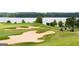 Scenic golf course view with lush green fairways, sand traps, and golfers enjoying a day on the course by the lake at 155 Cottage Club Dr, Locust Grove, GA 30248