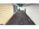 Side yard with fresh mulch, bordering the screened-in porch and privacy fence at 155 Cottage Club Dr, Locust Grove, GA 30248