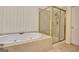 A bathroom featuring a bathtub, a shower with a glass enclosure, and tile flooring at 185 Newfield Dr, Tyrone, GA 30290