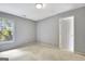 Cozy, carpeted bedroom with a window and a door, ready for personalization at 185 Newfield Dr, Tyrone, GA 30290