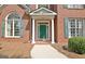 Classic brick home with a green front door, white columns, and well-maintained landscaping at 185 Newfield Dr, Tyrone, GA 30290