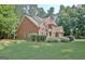 Charming brick home with lush landscaping, mature trees, and a well-manicured lawn at 185 Newfield Dr, Tyrone, GA 30290