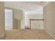 Upstairs hallway with neutral carpeting and trim, featuring a glimpse of a sunlit room at 185 Newfield Dr, Tyrone, GA 30290