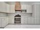 A stylish kitchen featuring white cabinets, a stainless steel oven and modern tile backsplash at 185 Newfield Dr, Tyrone, GA 30290
