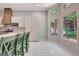 Bright kitchen with white cabinets, breakfast bar, and white tile flooring at 185 Newfield Dr, Tyrone, GA 30290