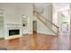 Open concept living room with fireplace, built-in shelving, staircase, and hardwood floors at 185 Newfield Dr, Tyrone, GA 30290