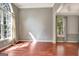 Bright living room with hardwood floors, large windows, and neutral walls at 185 Newfield Dr, Tyrone, GA 30290