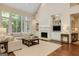 Cozy living room with a fireplace, built-in shelves, and large windows at 185 Newfield Dr, Tyrone, GA 30290