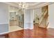 Open concept living room showcases hardwood floors, chandelier, and modern kitchen at 185 Newfield Dr, Tyrone, GA 30290