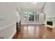 Bright living room features large windows, fireplace, built-ins, and hardwood flooring at 185 Newfield Dr, Tyrone, GA 30290