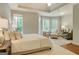 Bright primary bedroom featuring a cozy sitting area and tray ceiling at 185 Newfield Dr, Tyrone, GA 30290