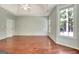 A large main bedroom featuring hardwood floors, a window, and a ceiling fan at 185 Newfield Dr, Tyrone, GA 30290
