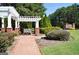 Picturesque pergola with bench and brick path surrounded by manicured landscaping at 185 Newfield Dr, Tyrone, GA 30290