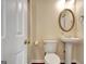 Classic powder room with pedestal sink, round mirror, and ample lighting at 185 Newfield Dr, Tyrone, GA 30290