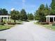 Community street showcasing manicured landscaping and inviting pergola, enhancing the neighborhood's charm at 185 Newfield Dr, Tyrone, GA 30290