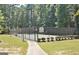 Outdoor tennis court surrounded by a fence and lush greenery, great for recreation at 185 Newfield Dr, Tyrone, GA 30290