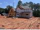 New two-story home under construction featuring black roof and a charming covered front porch at 140 Wilson Drive, Mcdonough, GA 30252