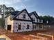 Two-story home under construction features black trim and a covered porch, offering a glimpse of future charm and appeal at 140 Wilson Drive, Mcdonough, GA 30252