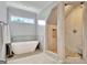 Bright bathroom showcasing a modern soaking tub and a luxurious walk-in shower with pebble stone flooring at 505 Lighthouse Ln, Peachtree City, GA 30269